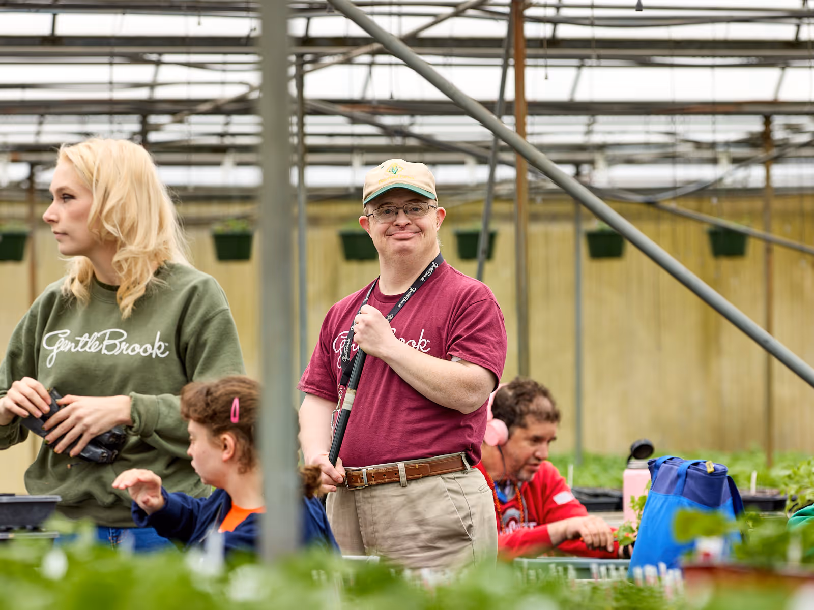 Man with developmental disabilities sweeping the floor outside a greenhouse at GentleBrook’s Hartville Adult Day Services, promoting responsibility and vocational skill-building in a supportive setting